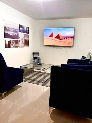 a living room with a couch and a tv on the wall at Outstanding Pent House w/Jacuzzi in Santiago de los Caballeros