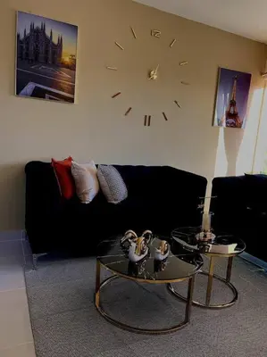 a living room with a couch and a clock on the wall at Magnificent Pent House w/Jacuzzi in Santiago de los Caballeros