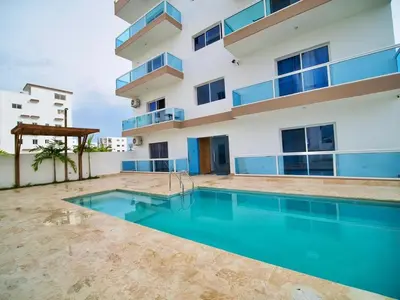 an apartment with a swimming pool in front of a building at Mar Azul in Bayahibe