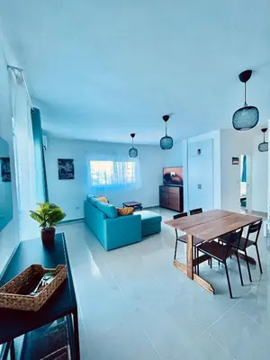a living room with a table and a blue couch at Mar Azul in Bayahibe
