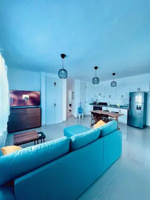 a living room with a blue couch and a kitchen at Mar Azul in Bayahibe