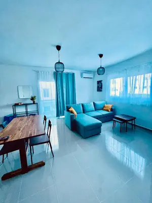 a living room with a blue couch and a table at Mar Azul in Bayahibe
