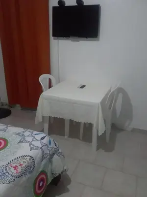 a white table with two chairs and a television on a wall at Best bed and breakfast in Samana Breakfast Included in Santa Bárbara de Samaná