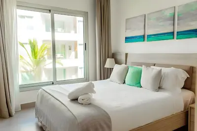 a bedroom with a bed with a large window at Beach Garden I F3 Luxury Condo in Punta Cana
