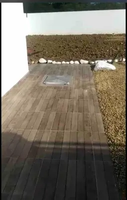 a wooden deck with a cover in the middle of a field at Privada tipo cabaña Con amplio patio in Santiago de los Caballeros