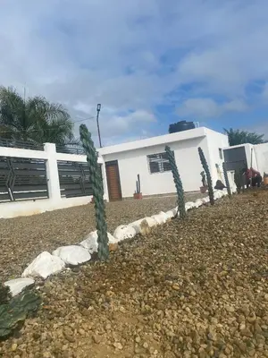a white house with cactus in front of it at Privada tipo cabaña Con amplio patio in Santiago de los Caballeros