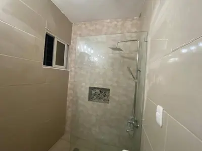 a shower with a glass door in a bathroom at Privada tipo cabaña Con amplio patio in Santiago de los Caballeros