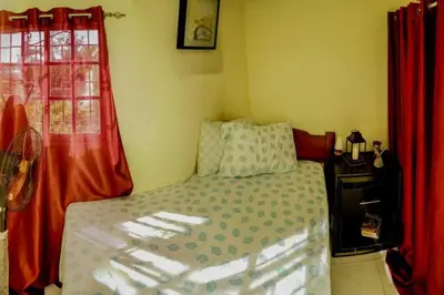 a small bedroom with a bed and red curtains at Apartamento en la Romana 2 días en adelante in La Romana