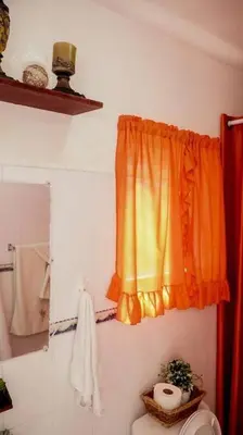 a bathroom with an orange curtain and a toilet at Apartamento en la Romana 2 días en adelante in La Romana