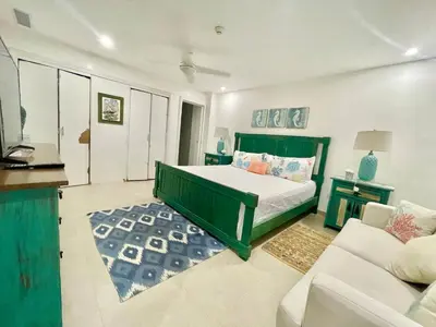 a bedroom with a green bed and a couch at 2 Bedroom At The Marbella Towers Beachfront in Juan Pedro