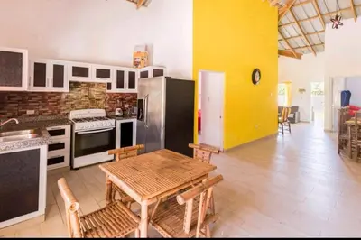 a kitchen with a table and a refrigerator at Sunflower village villa girasoles in Jarabacoa