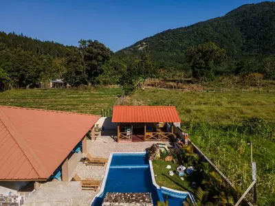 an aerial view of a house with a swimming pool and a building at Sunflower village villa girasoles in Jarabacoa