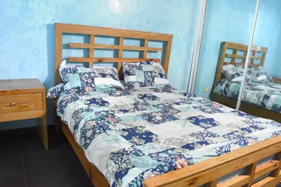 a bedroom with a bed with a quilt on it at Dpto Dream Village Boca Chica frente a la playa in Boca Chica