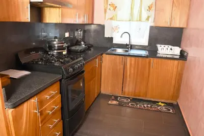 a small kitchen with a stove and a sink at Dpto Dream Village Boca Chica frente a la playa in Boca Chica