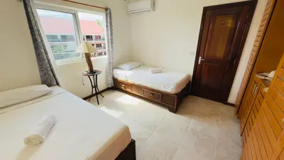 a small room with two beds and a window at Don Cesar Beachfront Apartments in Las Terrenas