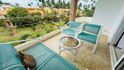 a balcony with a blue couch and a chair at Don Cesar Beachfront Apartments in Las Terrenas