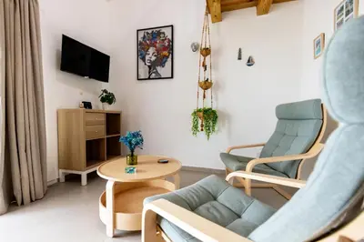 a living room with a couch and chairs and a tv at Esprit Caribbean Bayahibe in Bayahibe