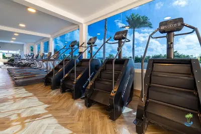 a row of treadmills in a gym with a large window at Playa Palmera Beach Resort in Punta Cana