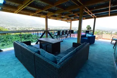 a living room with couches and a table and chairs at Villa Bellevue in San Felipe de Puerto Plata