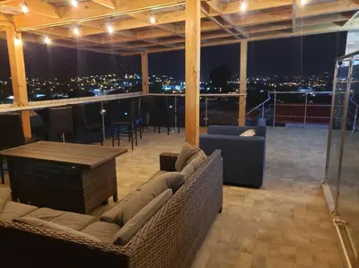 a room with couches and a table with a view of the city at Villa Bellevue in San Felipe de Puerto Plata
