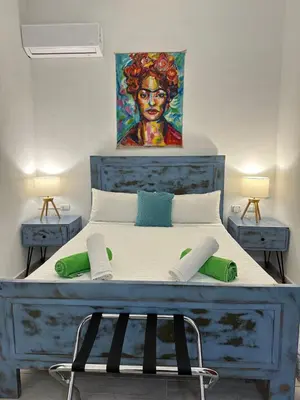 a bedroom with a blue bed with a painting on the wall at Paraíso Bayahibe in Bayahibe