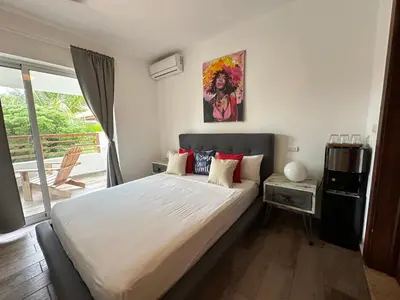 a bedroom with a large white bed and a window at Paraíso Bayahibe in Bayahibe