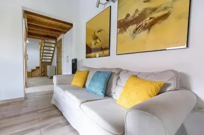 a living room with a couch and paintings on the wall at Paraíso Bayahibe in Bayahibe