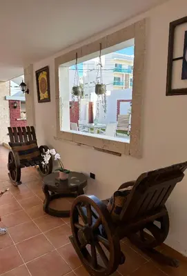 a living room with two rocking chairs and a table at Noe Hotel Punta Cana in Punta Cana