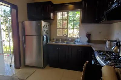 a kitchen with a stainless steel refrigerator and a sink at Dominican Art 2 Bedroom condo El Cortecito in Punta Cana