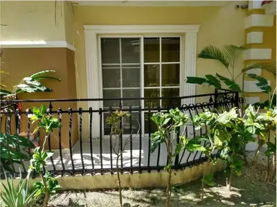 a fence in front of a house with plants at Dominican Art 2 Bedroom condo El Cortecito in Punta Cana