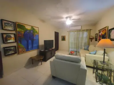 a living room with a couch and a tv at Dominican Art 2 Bedroom condo El Cortecito in Punta Cana