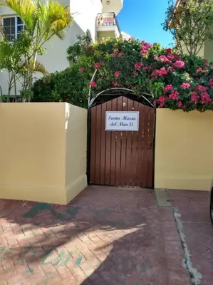a wooden gate with a sign on it with flowers at Dominican Art 2 Bedroom condo El Cortecito in Punta Cana