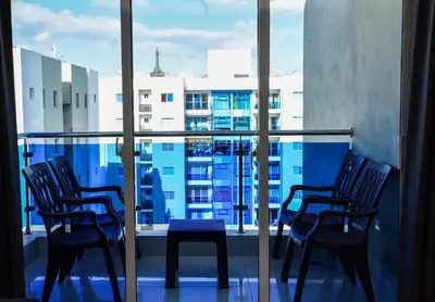 a balcony with chairs and a table and a window at Torre Real VI in Santiago de los Caballeros