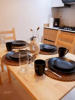 a wooden table with black plates and glasses on it at Hermoso refugio céntrico in Santo Domingo