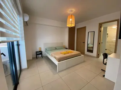a bedroom with a bed and a room with a mirror at Hermoso refugio céntrico in Santo Domingo