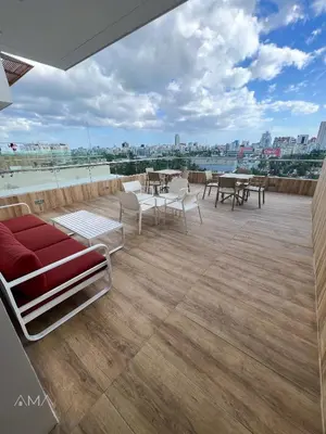 a large deck with chairs and tables on a roof at Hermoso refugio céntrico in Santo Domingo