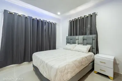 a bedroom with a bed with black curtains at Chuchi Place in Santiago de los Caballeros