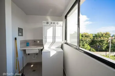 a white refrigerator in a kitchen with a window at Chuchi Place in Santiago de los Caballeros