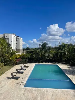 a swimming pool with lounge chairs and a building at Mountain View Cibao in Santiago de los Caballeros
