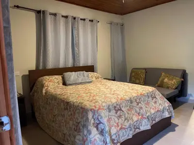 a bedroom with a large bed and a couch at Villa Zarina - Polo Barahona in Polo