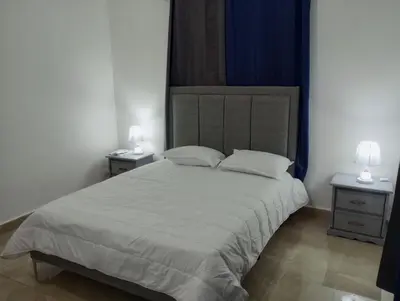 a bedroom with a large bed with two night stands at Departamento Rosa in Santo Domingo