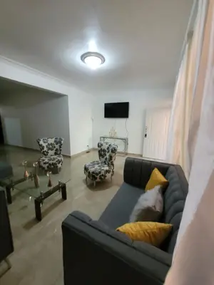 a living room with a blue couch and chairs at Departamento Rosa in Santo Domingo
