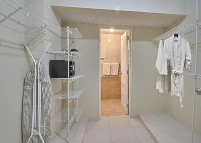 a bathroom with a walk in closet with a robe at Escape Penthouse near Blue Mall - 4BR with Private Rooftop & City Views in Santo Domingo