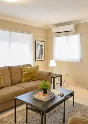 a living room with a couch and a table at Escape Penthouse near Blue Mall - 4BR with Private Rooftop & City Views in Santo Domingo