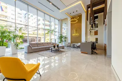 a lobby with a couch and chairs in a building at Brickell Apart Hotel in Santo Domingo