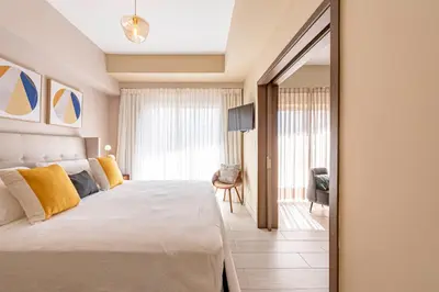 a bedroom with a large bed and a mirror at Brickell Apart Hotel in Santo Domingo