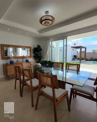 a dining room with a glass table and chairs at 2JA Management Group - SOV Properties in Sosúa