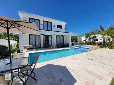 a villa with a swimming pool and a table with an umbrella at 2JA Management Group - SOV Properties in Sosúa