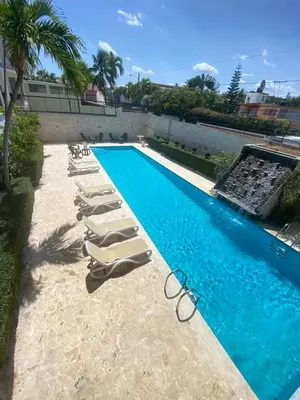 a swimming pool with lounge chairs next to a building at Hotel Checo Sosúa in Sosúa