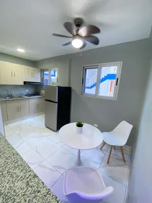 a kitchen with a table and chairs and a refrigerator at Hotel Checo Sosúa in Sosúa